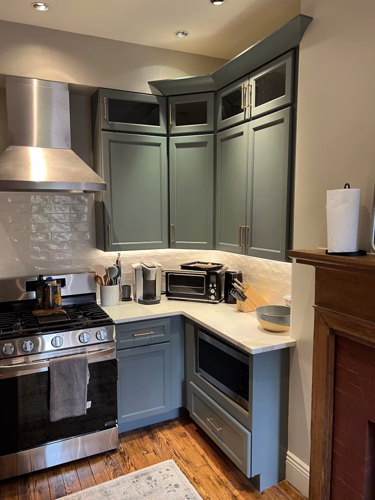 Kitchen remodel in Washington, DC with sage green J&K Cabinetry, white MSI quartz and stainless range hood by Kitchen & Bath Masters