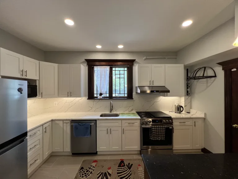 White shaker cabinets around the sink window with a marble-look backsplash and stainless appliances in Arlington, VA