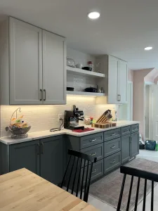 Coffee station corner with sage cabinets and white shelves in an Arlington, VA kitchen