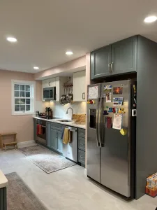 Galley view with sage cabinets and stainless refrigerator in a renovated Arlington kitchen