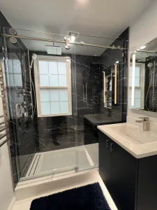 Bathroom Design in Arlington, VA Elena C. 7 Navy and black bathroom with glass shower and white integrated sink vanity in Arlington