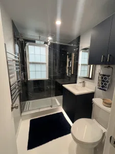 Bathroom Design in Arlington, VA Elena C. 4 Walk-in shower with sliding glass door, heated towel rack and white epoxy floor in Arlington, VA