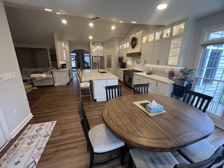 Open-concept kitchen remodel in Aldie, VA with Painted Vanilla Waypoint shaker cabinets, quartz island and wood-look flooring by Kitchen & Bath Masters