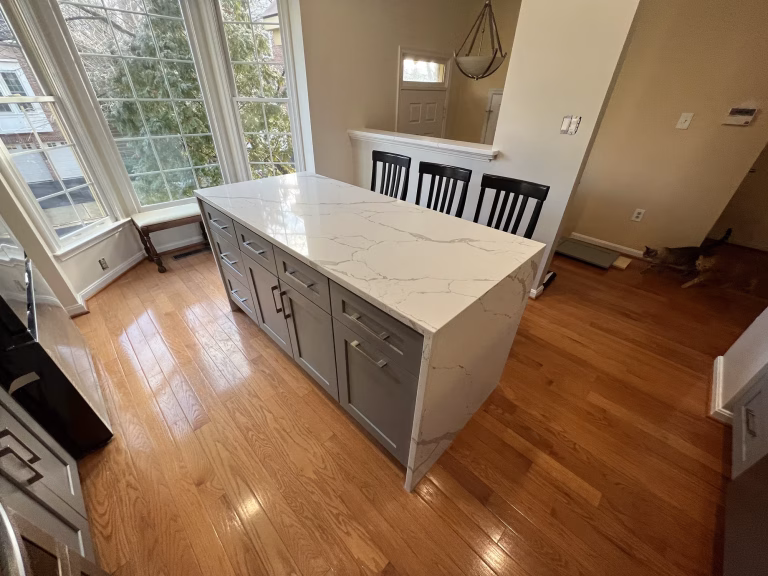 Kitchen remodel in Falls Church, VA with a gray shaker waterfall island in white MSI quartz by Kitchen & Bath Masters