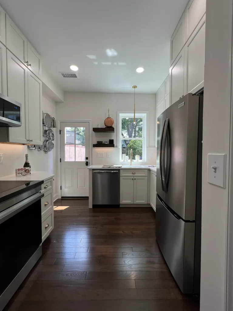 Remodeled galley kitchen in Washington, DC with Waypoint Dove shaker cabinets, quartz countertops and engineered wood floors by Kitchen & Bath Masters