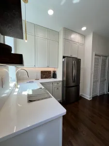 White quartz countertop and Dove shaker cabinets beside a stainless refrigerator in a Washington, DC kitchen remodel