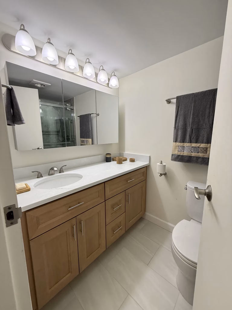 Bathroom remodel in Arlington, VA with a butterscotch J&K Cabinetry double vanity and white quartz top by Kitchen & Bath Masters
